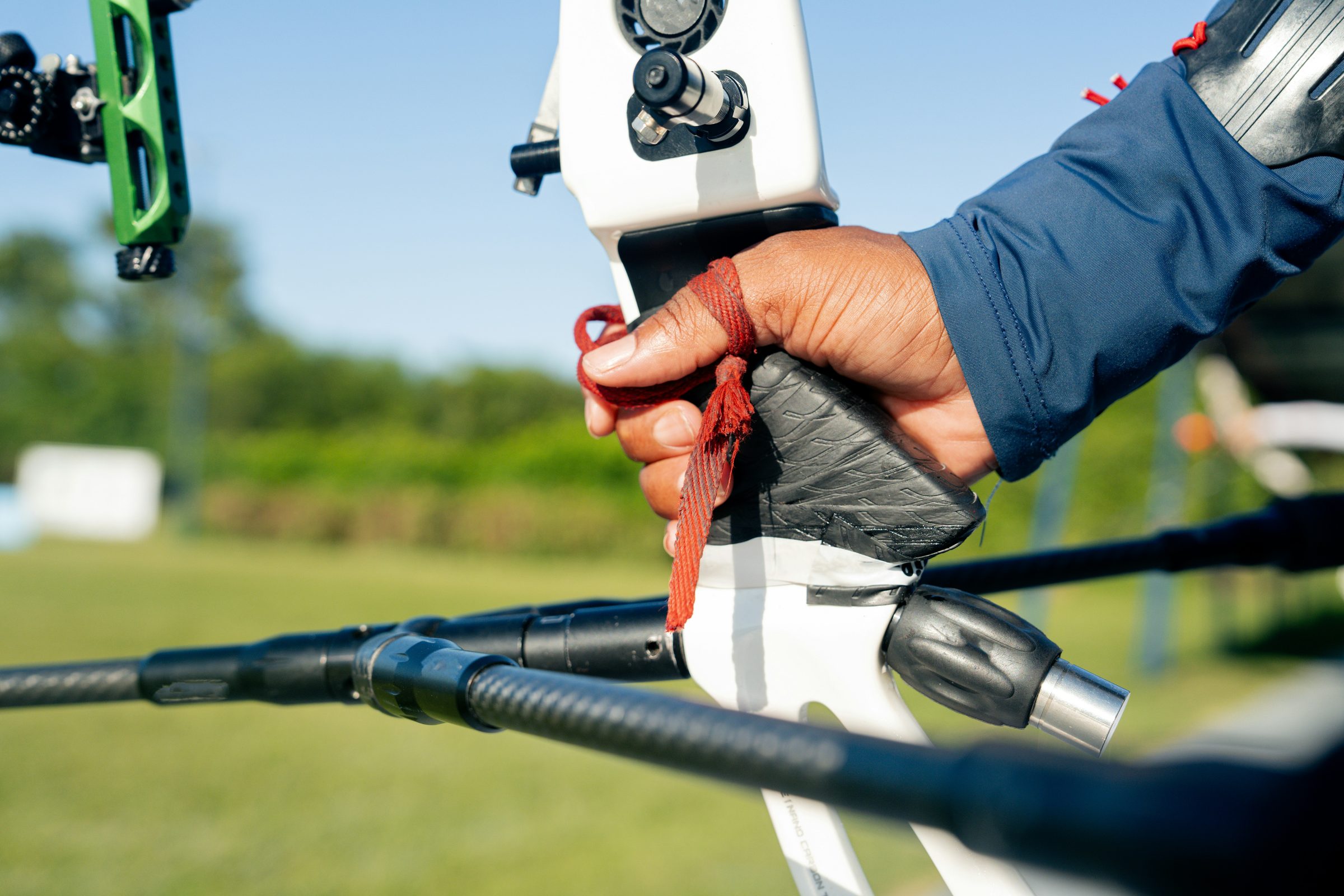 Close detail of proper grip and finger sling on a competition recurve